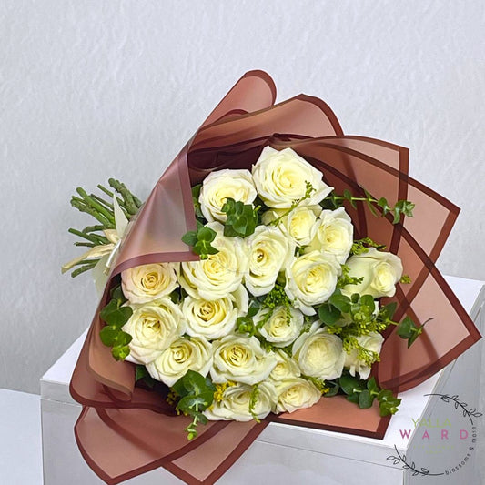 Bouquet of white roses wrapped in brown paper on a white background
