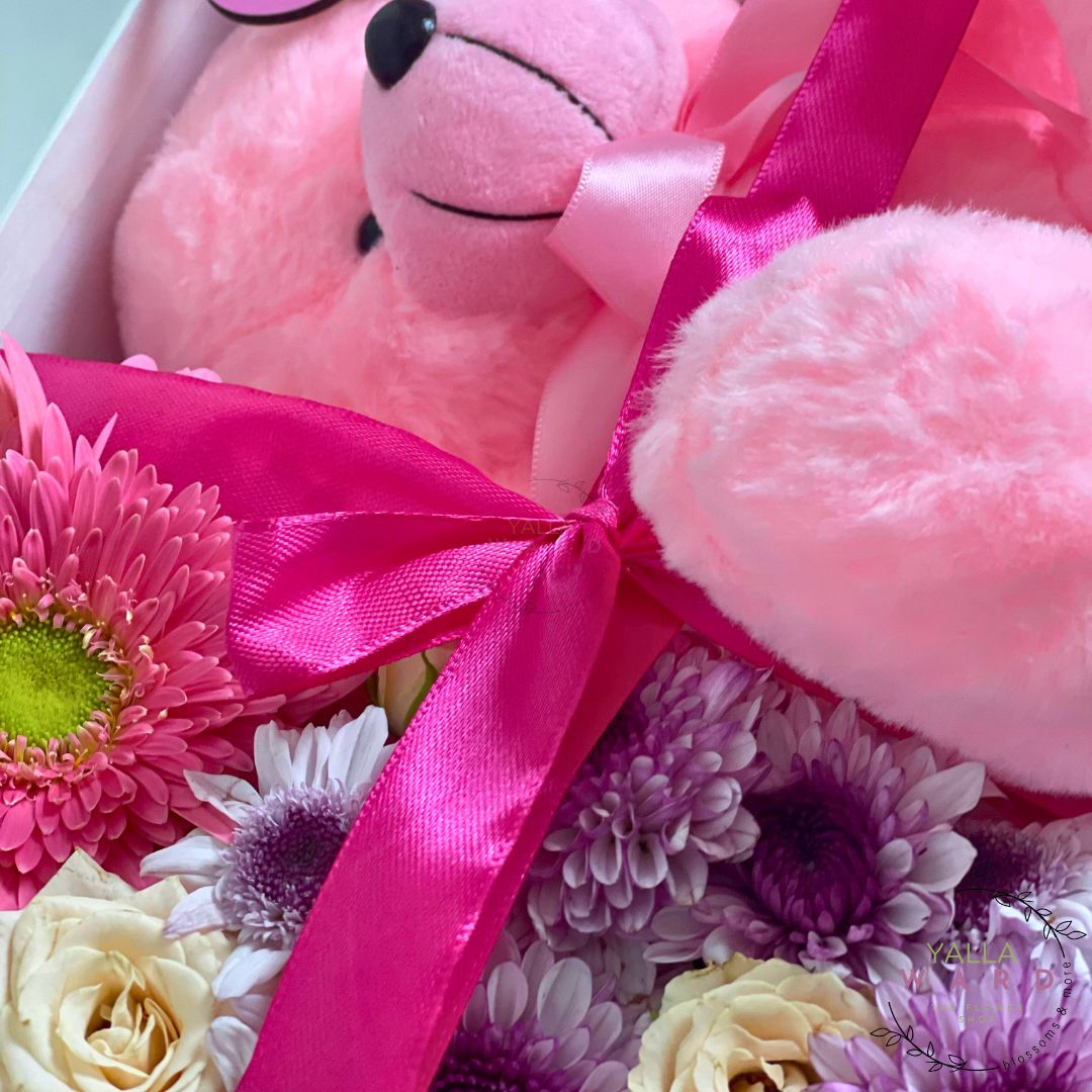 Pink teddy bear with flowers and a pink ribbon