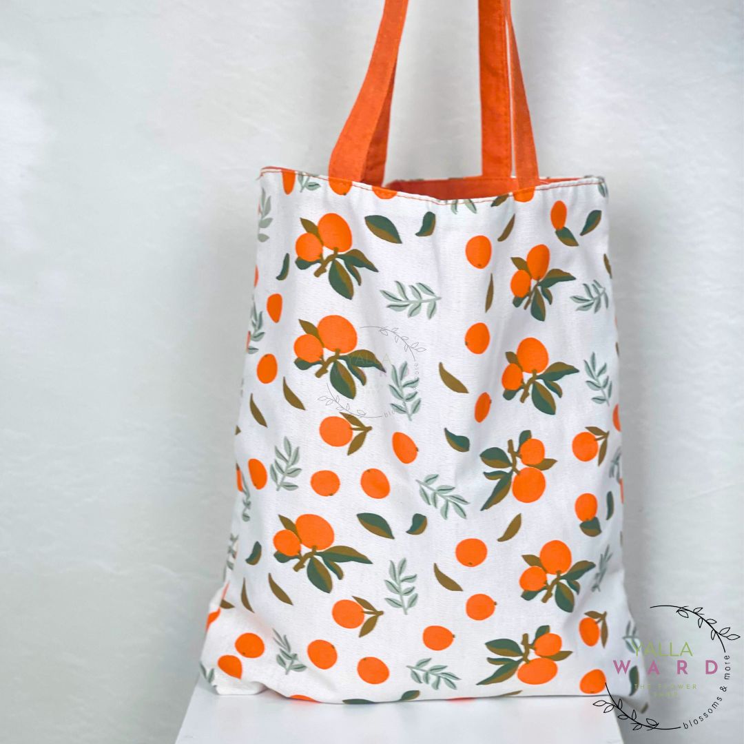 Tote bag with orange fruit pattern on a white background