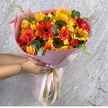 Bouquet of flowers held by a person against a gray background