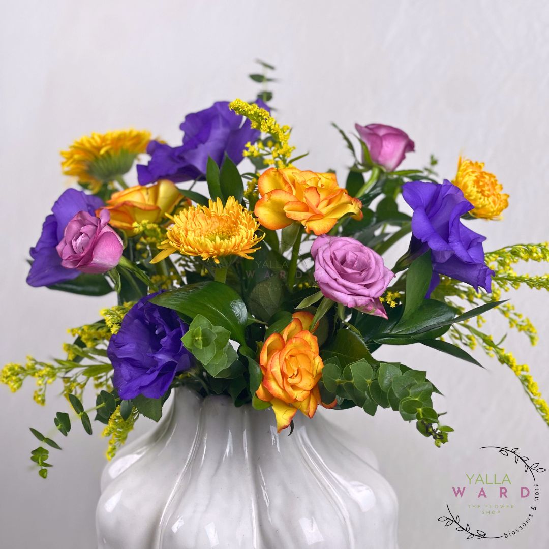 Colorful vase of flowers in a white vase on a light gray background