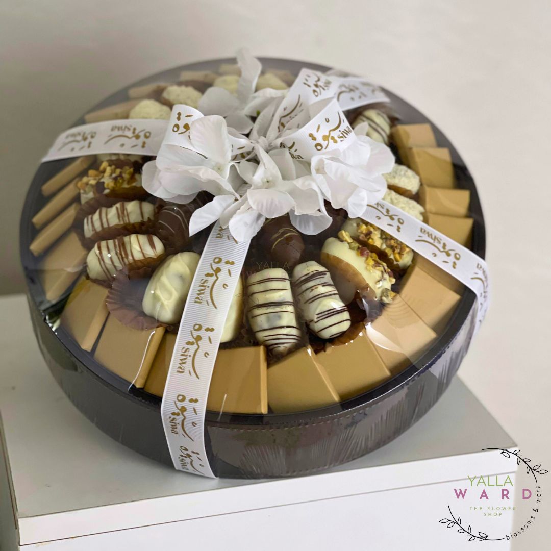 A circle chocolate gift box containing different types of chocolates on a white surface, branded "Yalla Ward".