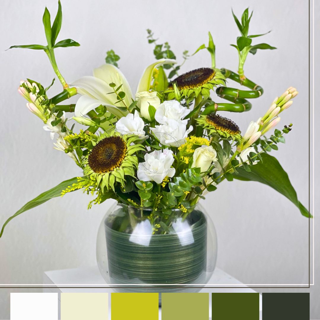flowers in a green vase on a white surface with a light gray background