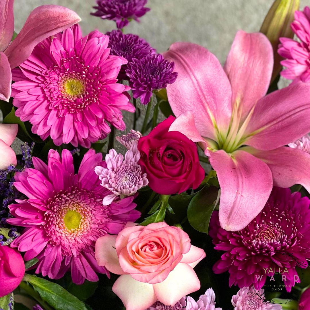 Bouquet of pink and purple flowers with a visible brand logo.