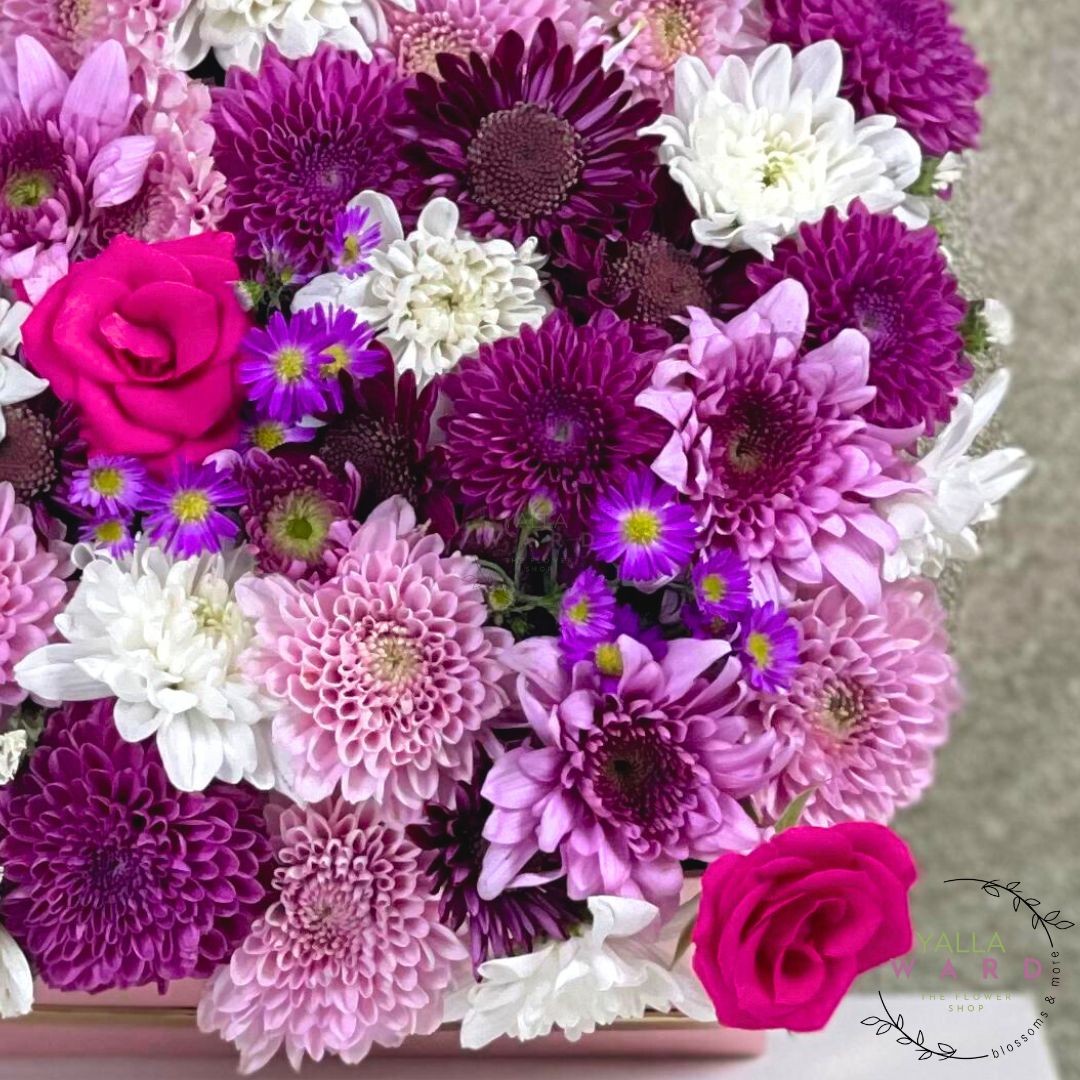 Bouquet of pink, purple, and white flowers with a visible brand logo in the corner.