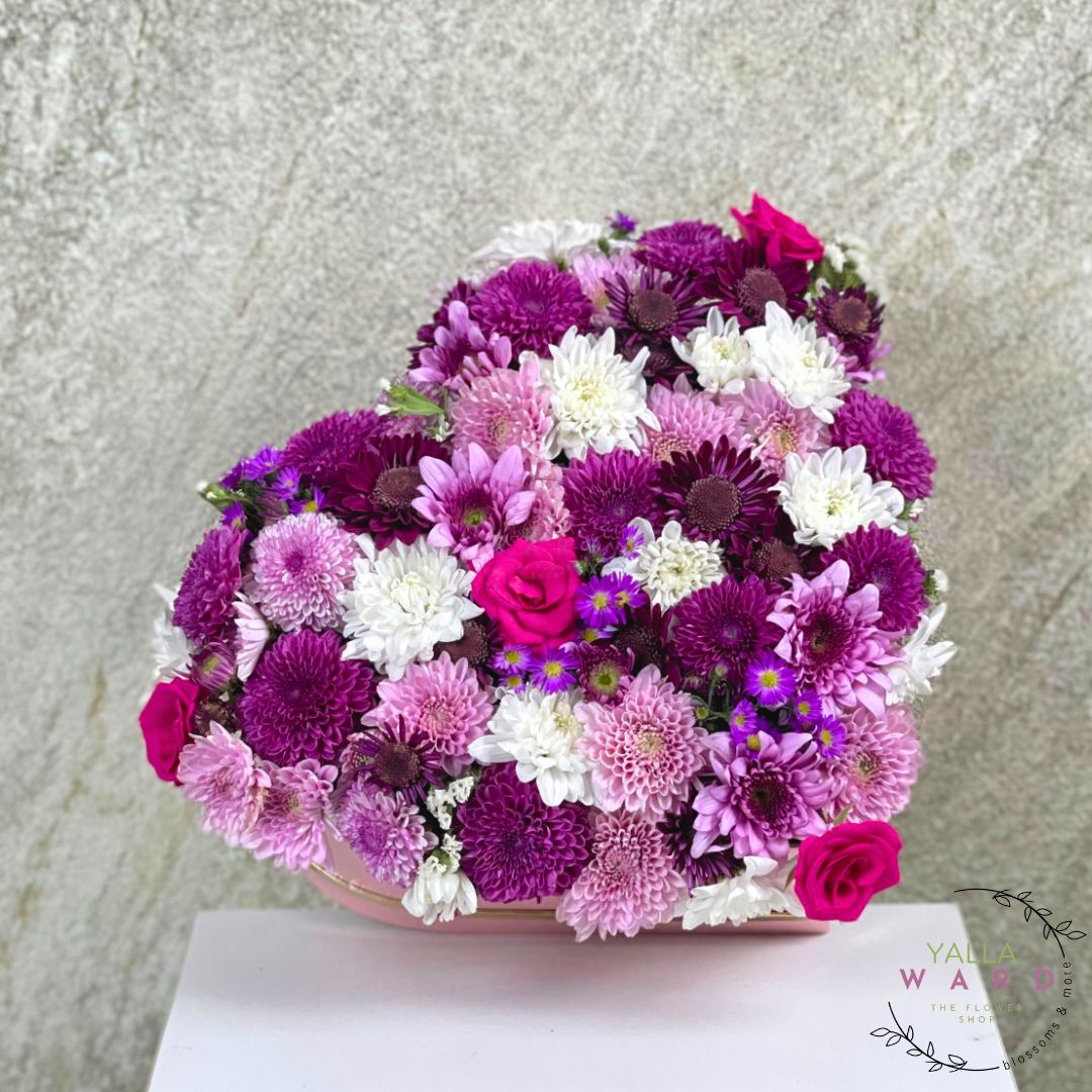 heart box in a purple, pink, and white flowers on a light gray background
