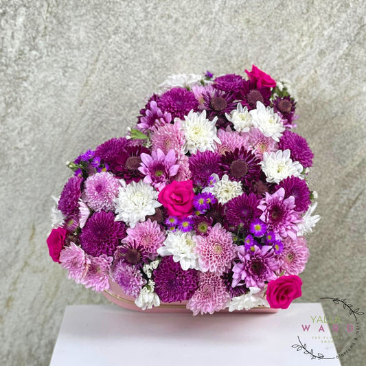 heart box in a purple, pink, and white flowers on a light gray background