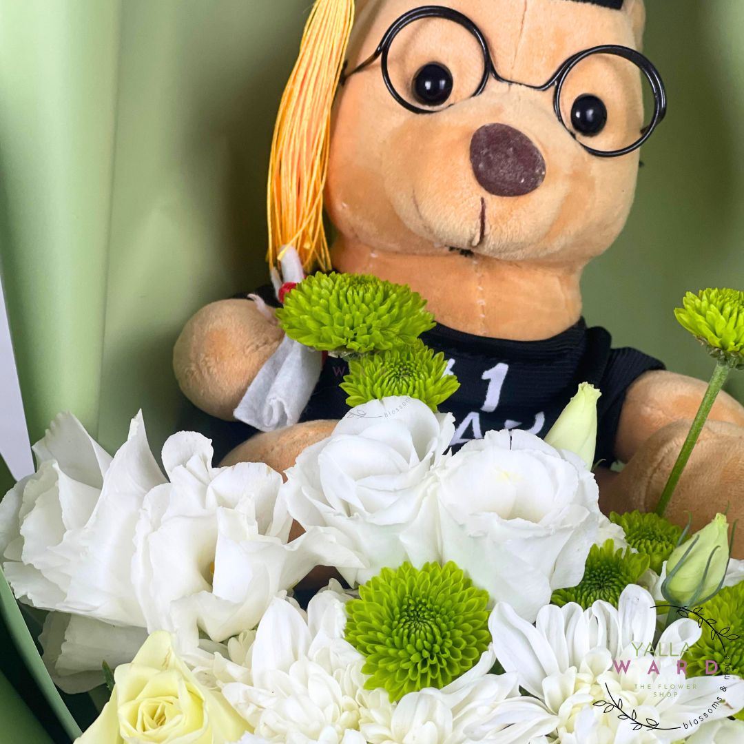 Teddy bear with glasses surrounded by white and green flowers