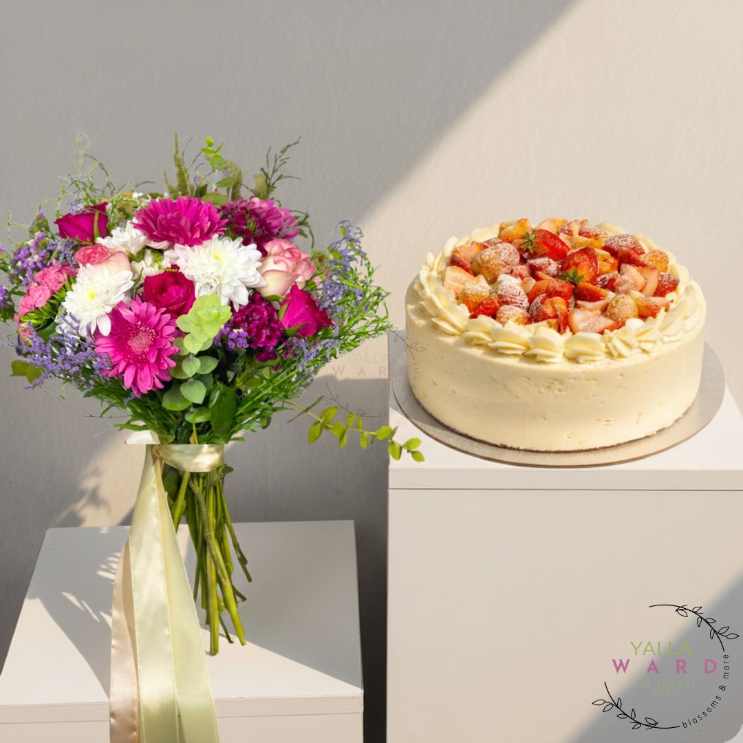 Bouquet of flowers in a vase next to a cake on a gray background